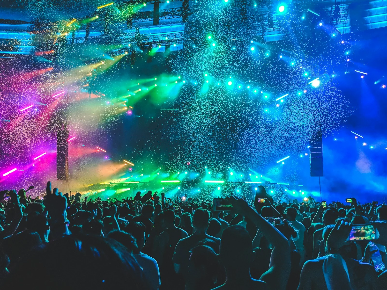 Concert crowd framed by luminous stage beams